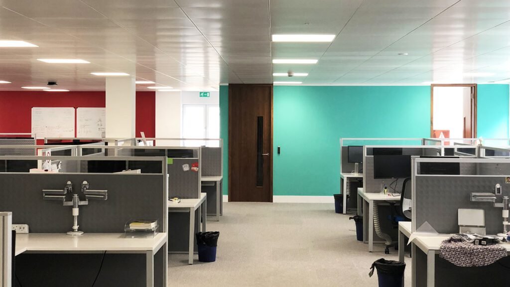 Interior Of An Office Showcasing Walls Painted In Two Vibrant Colors: Red And Light Green, Creating A Dynamic And Professional Workspace.